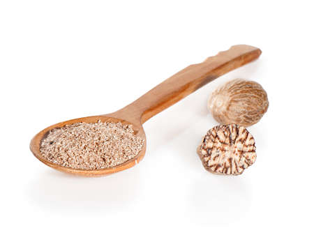 Whole and grated nutmeg in a wooden spoon on a white backgroundの写真素材