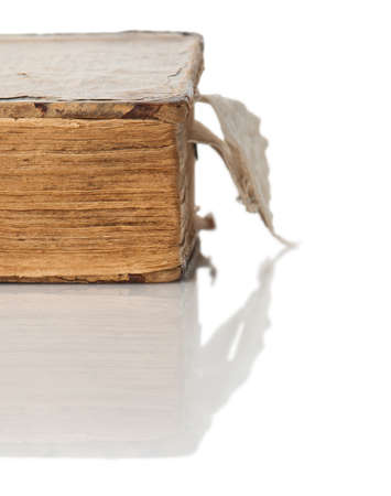 The old closed book with the turned yellow pages close up on a white background with reflection.の写真素材