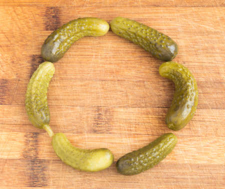 Round Frame of Homemade Pickled Gherkins with Copy Space. Marinated Cucumbers Over Rustic Wooden Backgroundの写真素材
