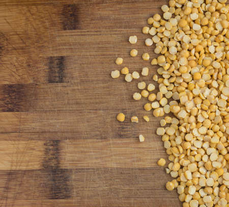 Dry Split Yellow Peas Scattered on the Rustic Wooden Background with Copy Spaceの写真素材