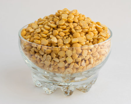 Dry Split Yellow Peas in Transparent Bowl on Old Wooden Cutting Board
