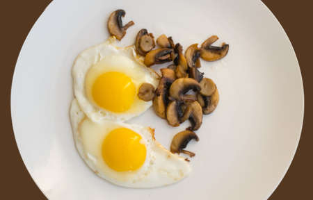 Fried Organic Eggs with Mushrooms on a White Plate Top Viewの写真素材