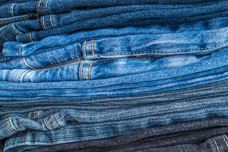 Stack of Blue and Gray Jeans. Denim Background or Texture with Seamsの写真素材