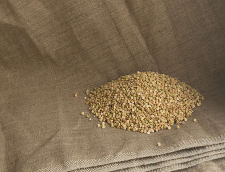 Dry Green Buckwheat Grain on Burlap Background. Healthy Cereal Vegetarian Foodの写真素材