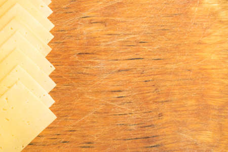 Sliced Cheese Over Rustic Wooden Background with Copy Spaceの写真素材