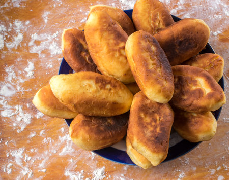 Traditional Homemade Baked Patties or Pies with Jam On Wooden Board. Fried Russian Pirozhki made...