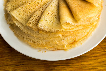 Stack of Thin Pancakes on a Wooden Background Top View. Fresh Homemade Crepes Flat Lay
