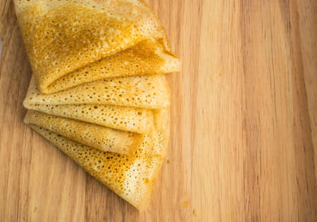 Thin Pancakes on a Wooden Background Top View. Fresh Homemade Crepes Flat Layの写真素材