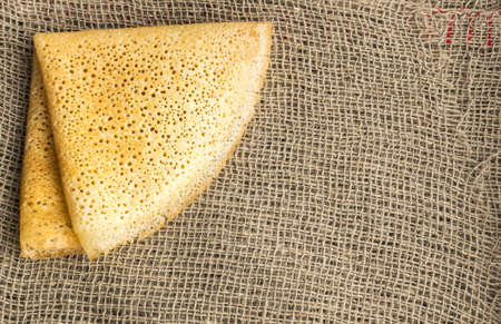 Thin Pancakes on a Burlap Background Top View. Fresh Homemade Crepesの写真素材