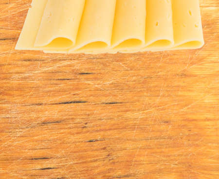Sliced Cheese Over Rustic Wooden Background with Copy Spaceの写真素材