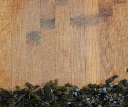 Heap of Dark Green Seaweed Salad on Old Wooden Cutting Board . Pickled Kelp or Laminaria Japonicaの写真素材