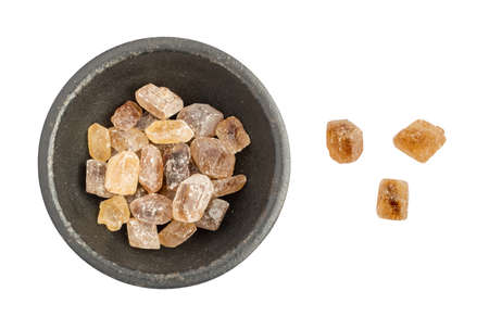 Large Crystals of Natural Unrefined Cane Sugar. Brown Lump Caramelized Saccharose on White Backgroundの写真素材