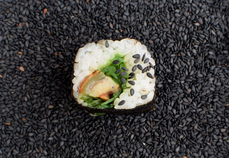 Sushi Roll with Smoked Eel and Seaweed Nori on a Dark Background of Black Sesame