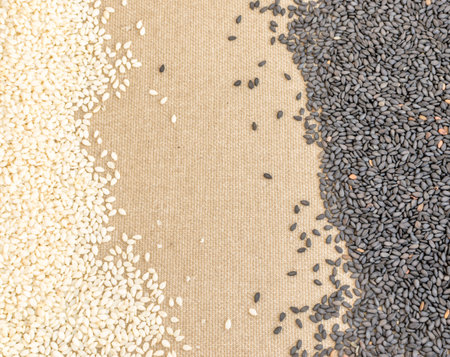 Heap of Black Sesame and White Sesame Seeds on Canvas Background with Space for Textの写真素材