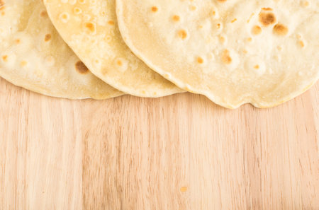 Plain Wheaten Flat Bread on a Wooden Background Top View. Fresh Homemade Flatbread also known as...