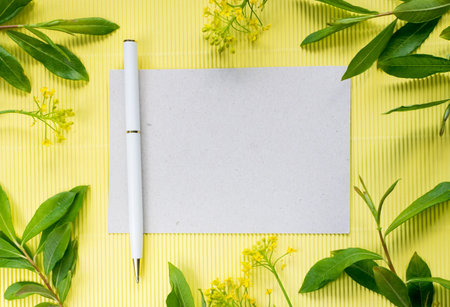 Summer Mocap with a White Ball Pen and a Clean Paper Surrounded by Leaves and Field Flowers. Summer...