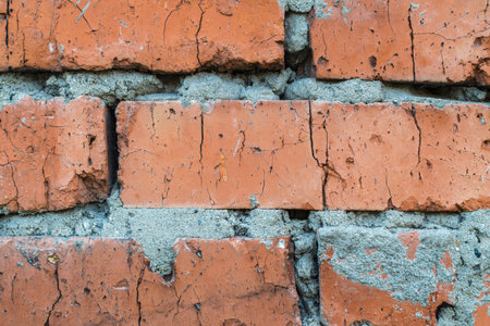 Old dirty brick wall with gray cement mortar closeup. Terracotta grunge stone texture