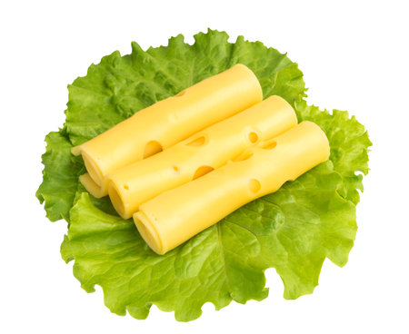 Sliced Maasdam Cheese with Green Lettuce Salad Isolated on White Background. Thin slices of yellow...