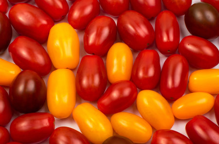 Red and yellow whole tomatoes pattern. Background with little cocktail tomatoes assortmentの写真素材