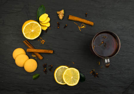 Lemon Spice Tea Ingredients with Cookies Top View on Dark Backgroundの写真素材