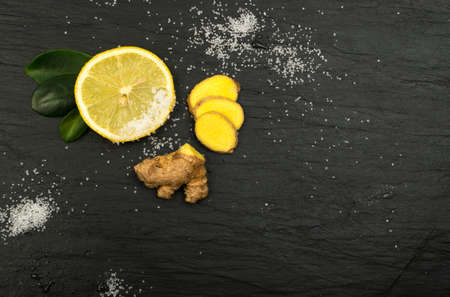 Fresh Sliced Ginger and Lemon with Sugar Top View on Black Backgroundの写真素材