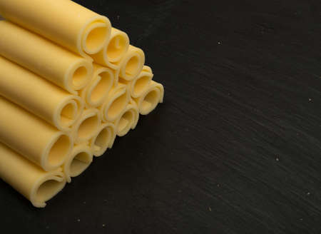 Sliced Cheese Over Black Stone Background with Space for Textの写真素材