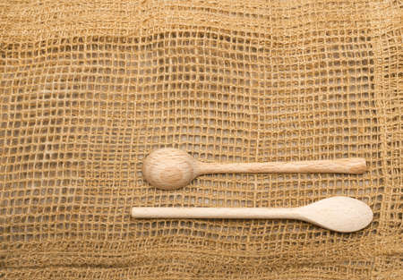 Rustic Burlap Background with Wooden Spoons Top View. Old Linen Canvas with Place for Text or Copyspaceの写真素材