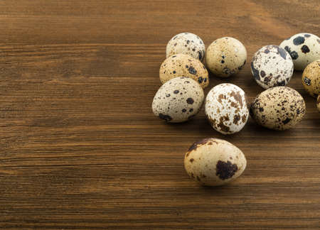 Quail Eggs on Wooden Rustic Background. Small Whole Eggs with Place for Textの写真素材