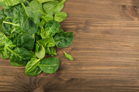 Fresh Baby Spinach Leaves. Spinacia Oleracea on Wooden Background. Leafy Green Vegetableの写真素材