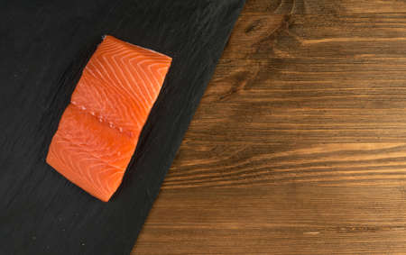 Sliced Salmon Fillet Top View. Thick Pieces of Fresh Red Fish or Trout on Black Backgroundの写真素材