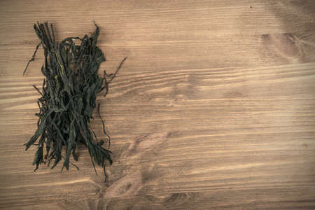 Dry Wakame Seaweed on Natural Wooden Background. Healthy Algae Foodの写真素材