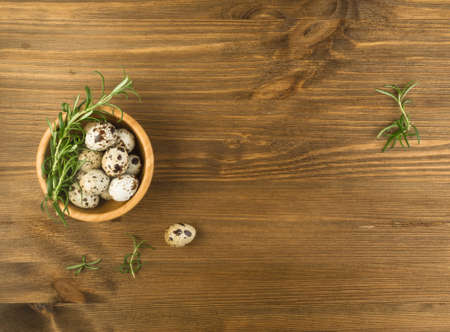 Quail Eggs on Wooden Rustic Background Top View. Small Whole Eggs with Place for Textの写真素材