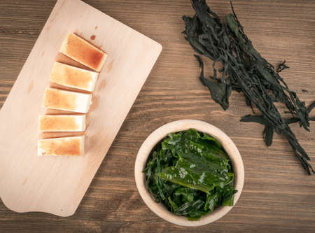 Dry Wakame Seaweed on Natural Wooden Background. Healthy Algae Food with Soy Sauce and Tofu Top Viewの写真素材