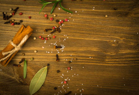 Dry Spices Mix with Black Pepper, Red Pepper, Green Rosemary, Clove and Bay Leaves on Old Wooden Background Top Viewの写真素材