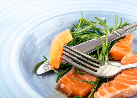 Eating Raw Sliced Salmon Fillet on Blue Plate. Thick Pieces of Fresh Red Fish or Troutの写真素材