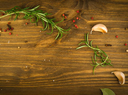 Dry Spices Mix with Black Pepper, Red Pepper, Green Rosemary, Clove and Bay Leaves on Old Wooden Background Top Viewの写真素材