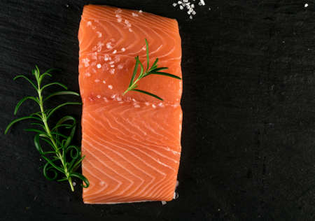 Fresh Salmon Fillet Top View. Thick Piece of Fresh Red Fish or Trout on Black Backgroundの写真素材
