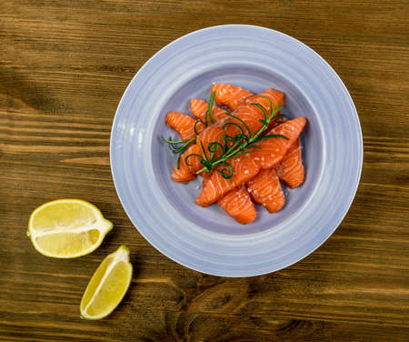 Raw Sliced Salmon Fillet on Blue Plate Top View. Thick Pieces of Fresh Red Fish or Troutの写真素材