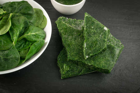 Fresh Baby Spinach Leaves. Frozen Spinacia Oleracea in White Bowl. Leafy Green Vegetable Top Viewの写真素材