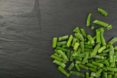 Chopped Frozen Green Beans on Stone Background Flat Lay and Top Viewの写真素材