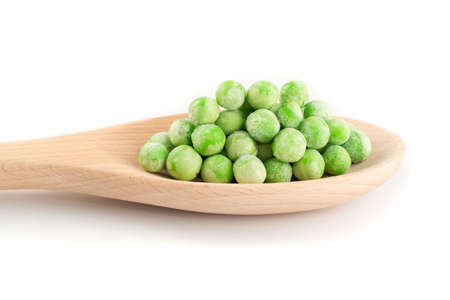 Heap of Frozen Sweet Green Peas in Wooden Spoon Isolated on White Backgroundの写真素材