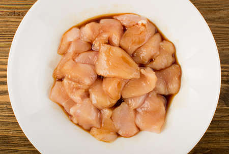 Raw Chicken Breast with Soy Souse in White Bowl. Fresh Turkey Fillet Chunks on Wooden Background Top Viewの写真素材