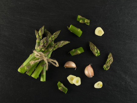 Chopped Raw Garden Asparagus with Garlic ready for Cooking Top View. Fresh Green Spring Vegetables...