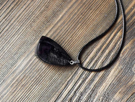 Pendant of Dark Color on Wooden Background. Bijouterie Made of Epoxy Resinの写真素材