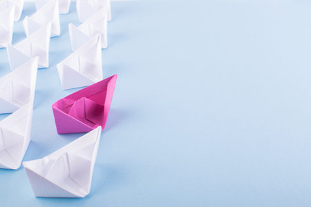 One Unique Pink Paper Boat among Many Ones. Different Paper Ships as Individuality and Leadership...