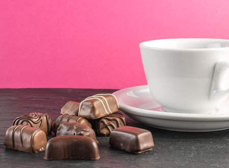 Beautiful Creative Chocolate Sweets on Natural Black Stone Background. Mix of Chocolates with Coffee...