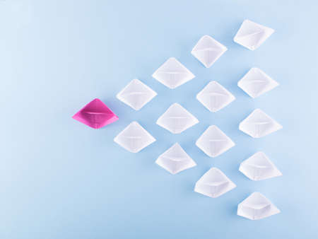 One Unique Pink Paper Boat among Many Ones. Different Paper Ships as Individuality and Leadership Conceptの写真素材