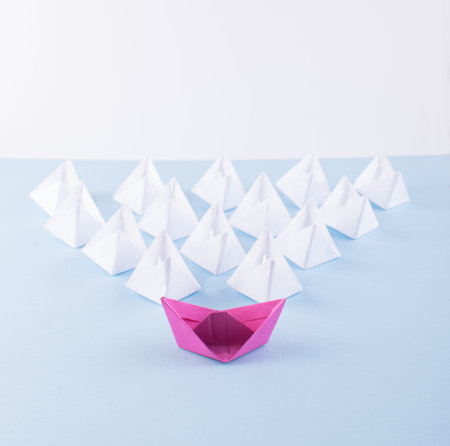 One Unique Pink Paper Boat among Many Ones. Different Paper Ships as Individuality and Leadership...