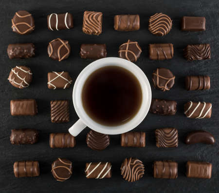 Beautiful Creative Chocolate Sweets on Natural Black Stone Background. Mix of Chocolates Top View and Flat Layの写真素材