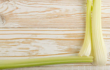 Raw green celery stalks on wood background top view. Fresh organic vegetables on old wooden rustic table with place for text or copyspaceの写真素材